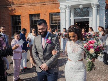 Happy wedding couple outside manor house